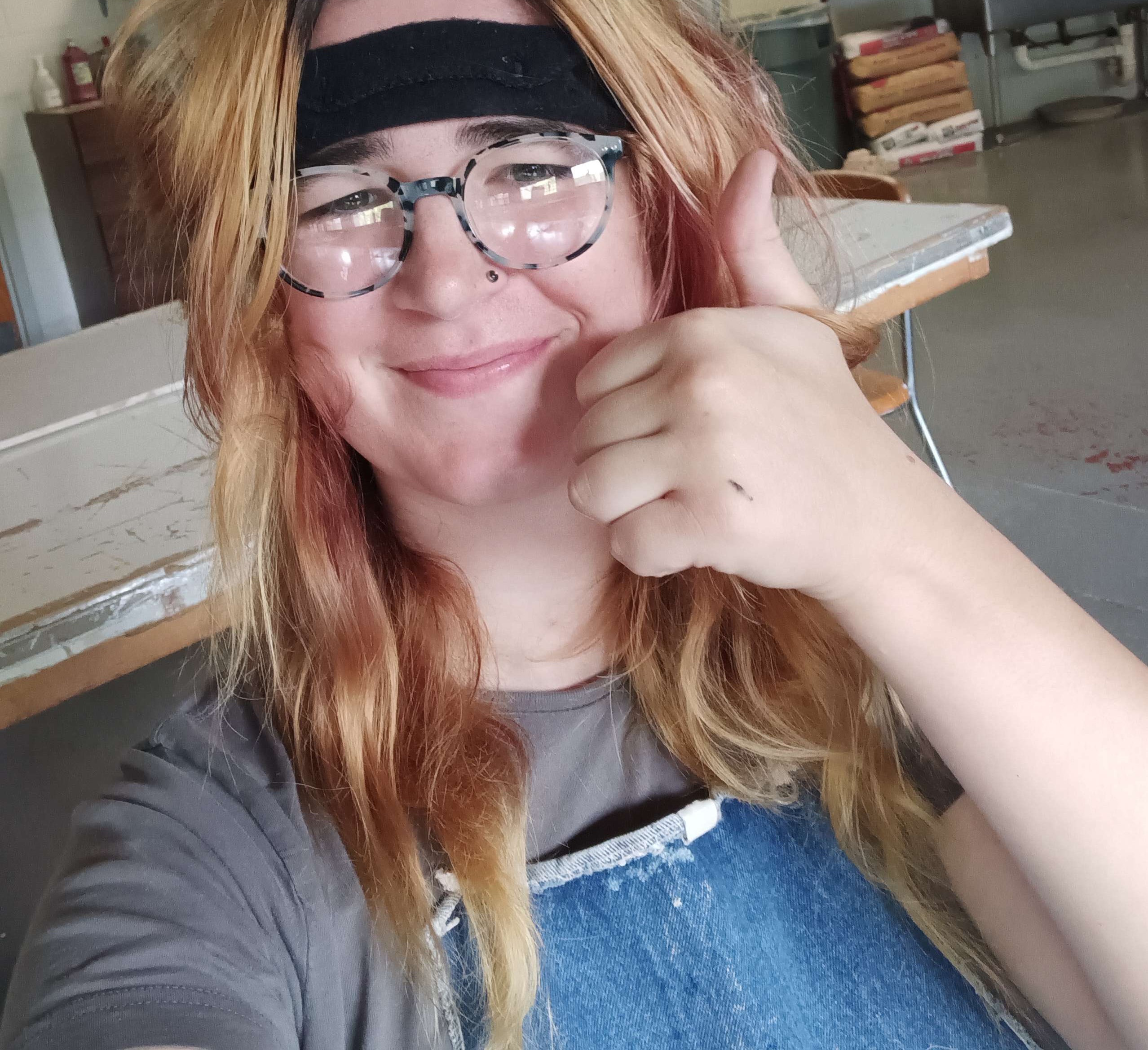 Joanie wearing a protective face shield and giving a thumbs up