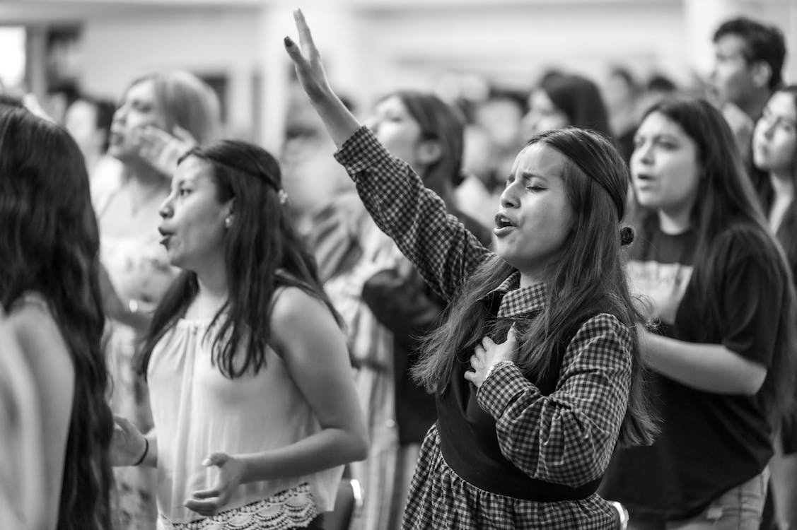 A young woman holding her hands up in church