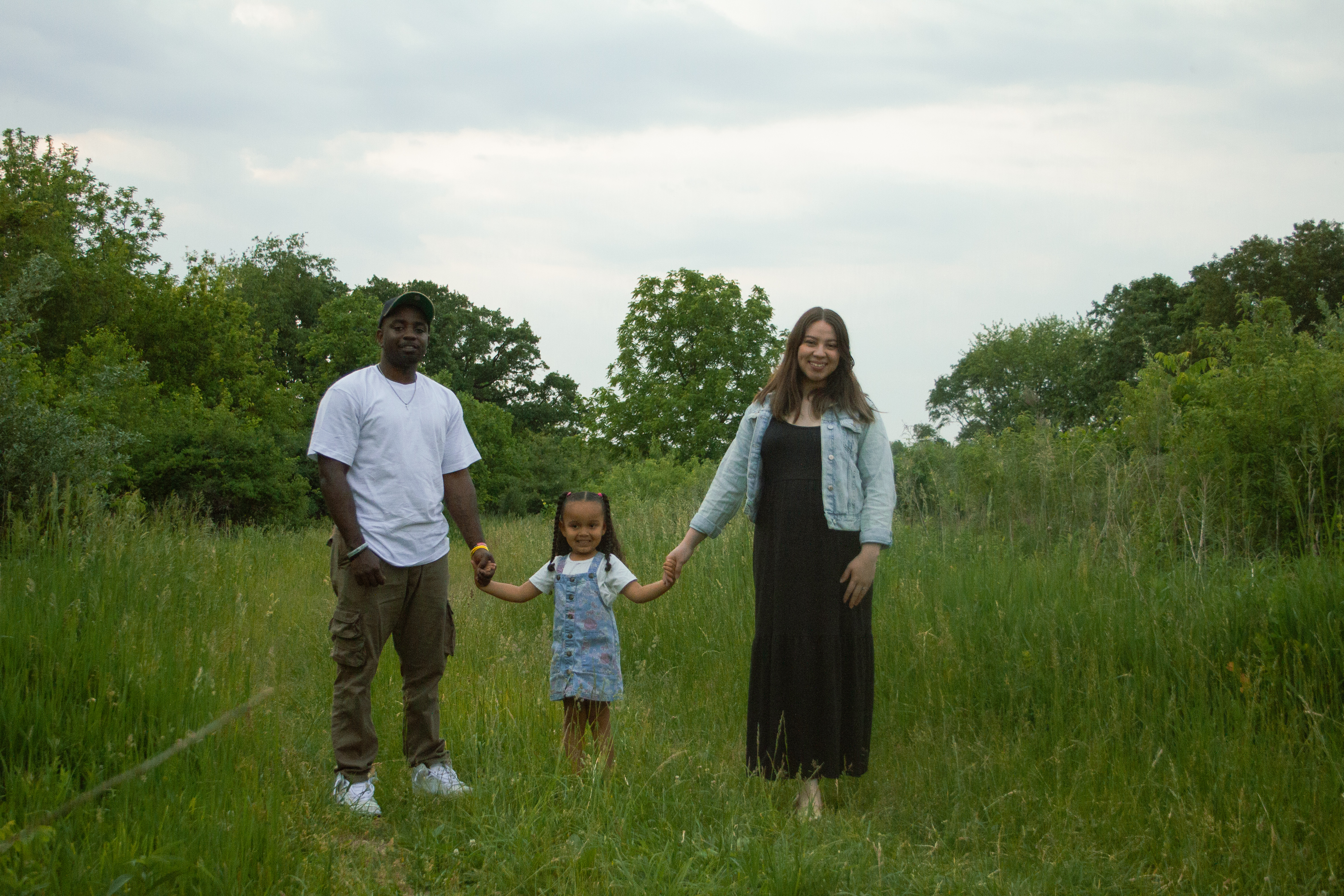 A family of three standigng in grass