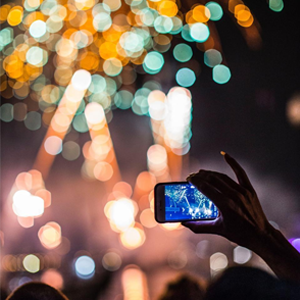 Person recording fireworks at night